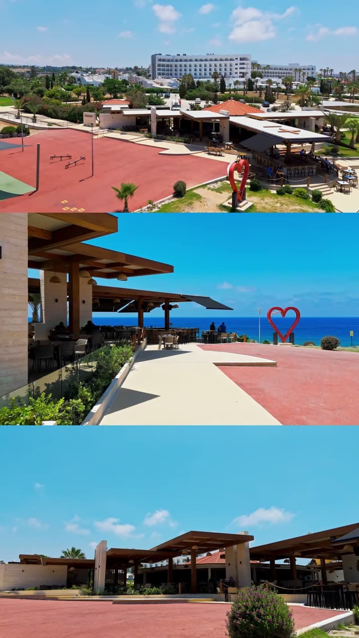 An aerial drift over the blue coastline to the red heart sculpture by the sea at Baracas.